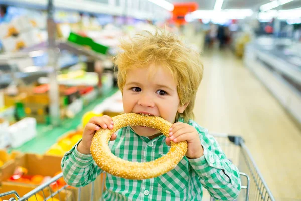 Lezzetli yemekler. Bir çocuk süpermarkette çörek yer. Snack. — Stok fotoğraf