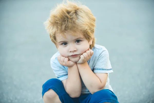 Pensive gyermek. Nyugodt fiú. A gyermek pihen az utcán. Gyönyörű portré. — Stock Fotó