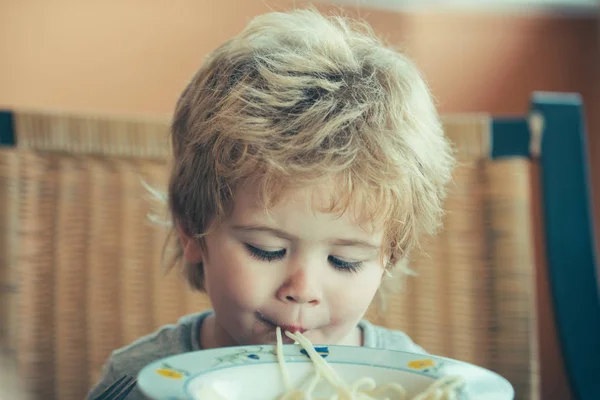Ребёнок ест спагетти. Вкусный обед для детей. Итальянская кухня . — стоковое фото