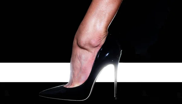High heel. Fashion. Female foot in a black shoe. High Fashion Week. High rise of the foot. Elegant female legs. Fashionable patent leather shoes.
