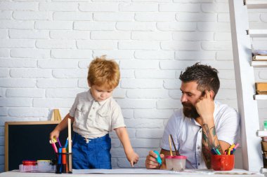 Okul, yaratıcı eğitim. Çizim aile, baba nasıl oğlu çizer görünüyor. Çocuk bahçesinde gelişim, öğretmen öğretmen ve pedagoji, sanat terapisi. Küçük sanatçı keçeli kalemlerle resim yapıyor.
