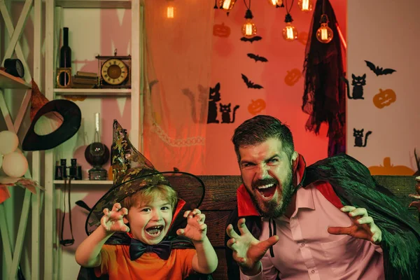 Страшная семья на Хэллоуин. Открытка. Отец и сын пугают руками. Ужасная традиция. Семейный праздник. Волшебники папа и мальчик. Открытка . — стоковое фото