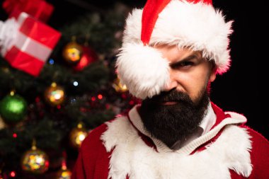 Seksi Noel Baba. Noel Baba şapkalı sakallı bir adam kameraya bakıyor. Yeni yıldan önce bir giyim mağazasında indirim var. Noel modası.