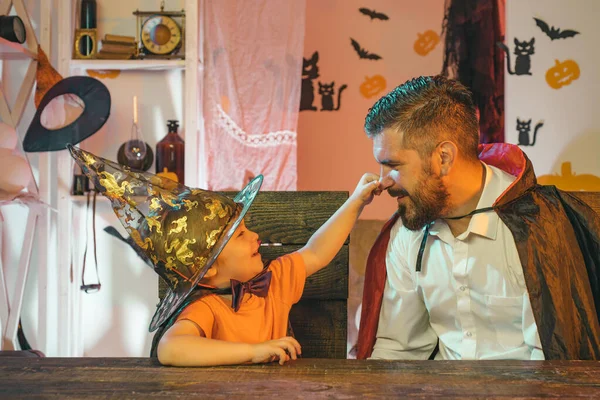 Αποκριάτικο πάρτι. Αστεία οικογένεια. Το αγόρι αγγίζει τον πατέρα του από τη μύτη. Άνετο πάρτι στο σπίτι για τις διακοπές του Halloween. — Φωτογραφία Αρχείου