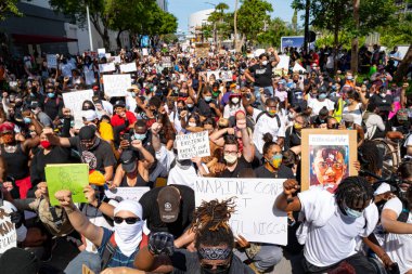 Miami Downtown, FL, USA - MAY 31, 2020: George Floyd protests spread across America. Crowds of white and black people at a demonstration for human rights. Black lives matter. clipart