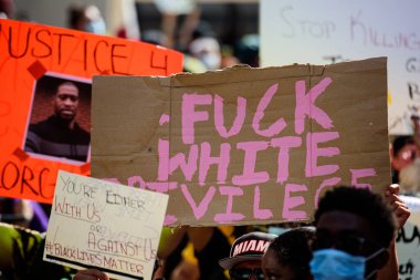 Miami Downtown, FL, USA - MAY 31, 2020: Against white Privilege poster. Justice for George Floyd. Peaceful protests after Floyd death. clipart