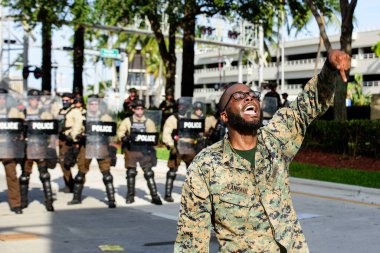 Miami Downtown, FL, ABD - 31 Mayıs 2020: Miami bölgesi polisi ve protestocuları. Yüzleşme. Amerika Birleşik Devletleri 'ndeki toplu protestolar sırasında Amerikan polisi ve siyahi insanlar arasındaki çatışma.