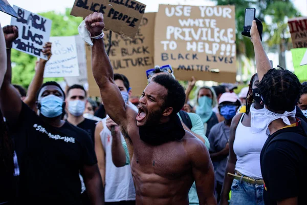 Miami Downtown, FL, USA - MAY 31, 2020: Protests for the rights of black people. 피부가 검은 감정적 인 남자 가손을 위로 들고 있다. 조지 플로이드가 죽은 후 시위에 참여 했다. 크림. — 스톡 사진
