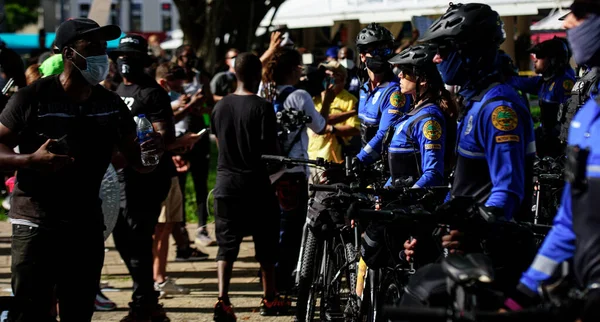 Miami Downtown, FL, USA - MAJ 31, 2020: Policjanci Miami i czarny człowiek na demonstracji. Policja i protestujący w Miami. Protesty rozprzestrzeniły się po całych Stanach Zjednoczonych.. — Zdjęcie stockowe