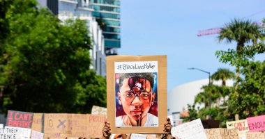 Miami Downtown, FL, USA - MAY 31, 2020: Black Lives Matter poster. People on streets in cities across the U.S. after a white police officer charged with the murder of unarmed black man George Floyd. clipart