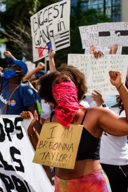 Miami Downtown, FL, ABD - 31 Mayıs 2020: Ben Breonna Taylor posteri. Amerika 'da George Floyd' un ölümüne karşı barışçıl protestolarda bulunan bir kadın: insanlar protesto ediyor. Kadın eylemci protestocu.