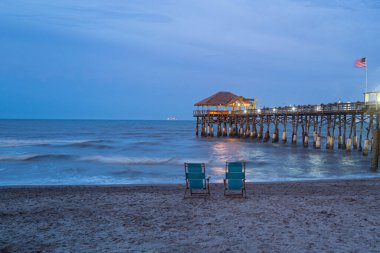 Okyanusun kenarında iki boş sandalye. İki kişilik plaj. Bir çift. Romantik bir akşam. Atlantik Okyanusu 'nun turkuaz sularının yanındaki turkuaz sandalyeler..