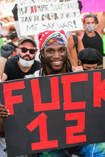 Miami Downtown, FL, USA - MAY 31, 2020: Happy black man with poster Fuck 12. Protest agains US police. — Stockfoto
