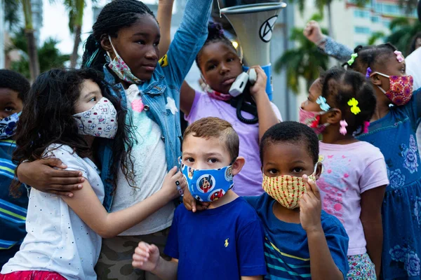 Miami, FL, USA - 7 czerwca 2020: Białe i czarne dzieci razem. Uczniowie i młodzież na demonstracji w USA po śmierci George 'a Floyda. — Zdjęcie stockowe