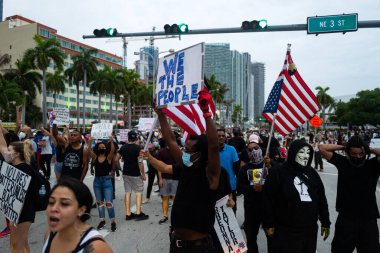 Miami, FL, ABD - 7 Haziran 2020: ABD 'deki gösterilerde Amerikan bayrağı ve posterleri olan insanlar.
