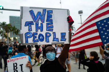 Miami, FL, ABD - 7 Haziran 2020: Afişi olan siyahi adam Biz Halkız. Amerika 'da gösteriler ve George Floyd' un ölümünden sonra ırkçılığa karşı protestolar.