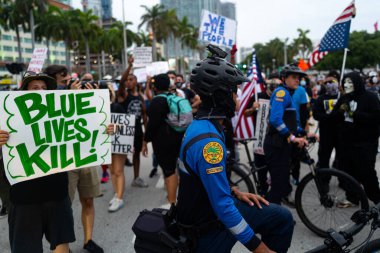 Miami, FL, ABD - 7 Haziran 2020: Protestocular, beyaz bir polis memurunun silahsız bir siyahi adamı öldürmekle suçlanmasının ardından ABD 'nin dört bir yanındaki sokaklara döküldü. Devriye ve protestocular.