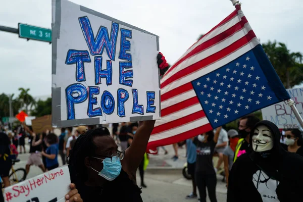 Miami, FL, USA - 07 czerwca 2020: Czarny człowiek z plakatem We the people. Demonstracje w USA. — Zdjęcie stockowe