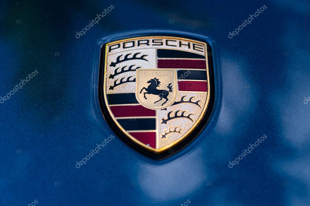 Miami, Florida, USA - JUNE 2020: : Porsche Logo Close Up on a blue car. Ferdinand Porsche founded the company with main offices in the centre of Stuttgart