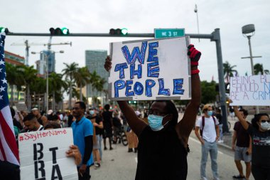 Miami, FL, ABD - 7 Haziran 2020: Afişi olan siyahi adam Biz Halkız. Amerika 'da gösteriler ve George Floyd' un ölümünden sonra ırkçılığa karşı protestolar.