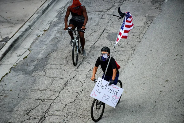 Miami Downtown, FL, USA - 12 ΙΟΥΝΙΟΥ 2020: Οι μαύρες ζωές μετράνε. Μαύρος άντρας με σημαία και αφίσα. Διαδηλώσεις κατά του ρατσισμού στις ΗΠΑ. — Φωτογραφία Αρχείου