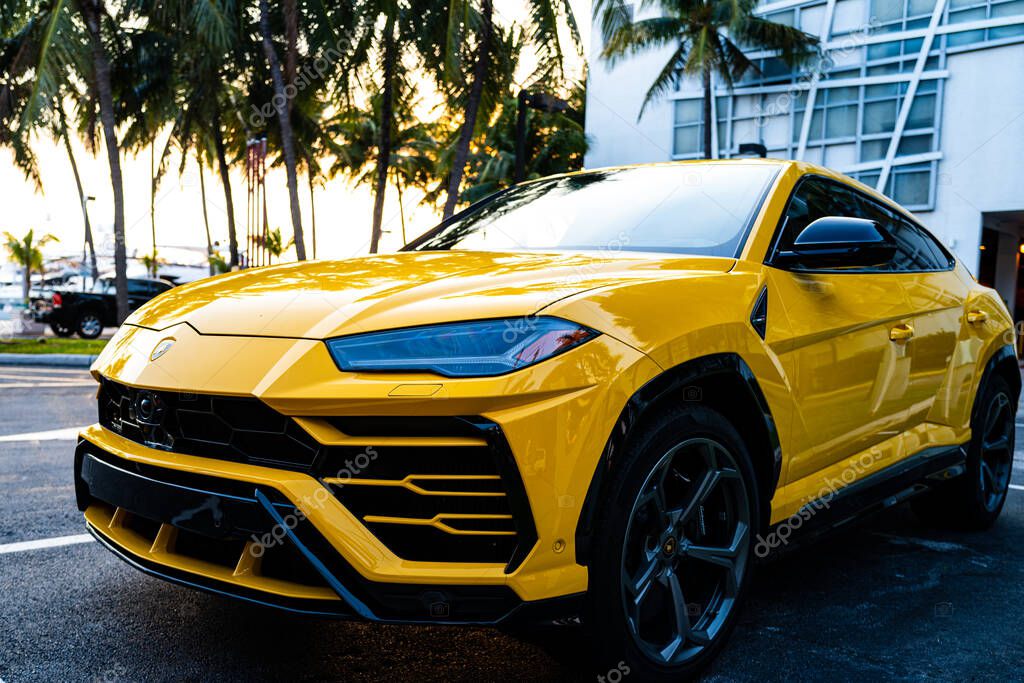 Miami, Florida, USA - JUNE 2020: Lamborghini logo. Yellow super beautiful expensive car. Horsepower. Elegant transport. Luxury life. Car parked in American city street in Miami Beach