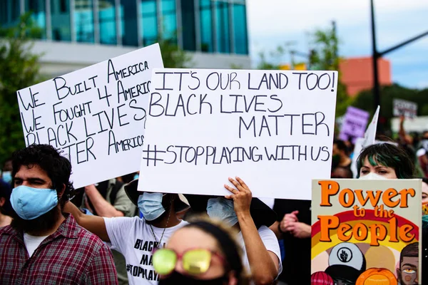 Orlando, FL, Estados Unidos - 19 de junio de 2020: Protestas masivas en Estados Unidos. Gente blanca y negra contra el racismo y la crueldad. Potencia al cartel del pueblo . — Foto de Stock