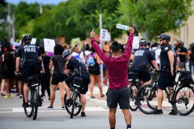 Orlando, FL, ABD - 19 Haziran 2020: Polis ve göstericiler. Polis eylemlerine karşı protesto. Genç adam bir polise parmağını gösterdi..