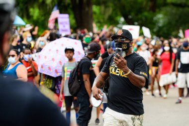 Orlando, FL, ABD - 19 Haziran 2020: Siyahların Yaşamı Önemlidir. Birçok Amerikan vatandaşı George Floyd 'un ölümüne karşı barışçıl protestolara katıldı: insanlar protesto ediyorlar. Beyaz ve siyah birlikte..