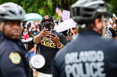 Orlando, FL, ABD - 19 Haziran 2020: siyah adam ve şiddet işareti. Amerika 'da ırkçılığa karşı gösteriler. Polis ve protesto.