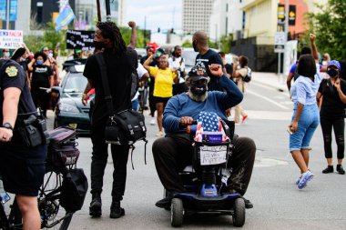 Orlando, FL, ABD - 19 Haziran 2020 Tekerlekli sandalyedeki adam. ABD sokaklarında protesto yapan insanlar..