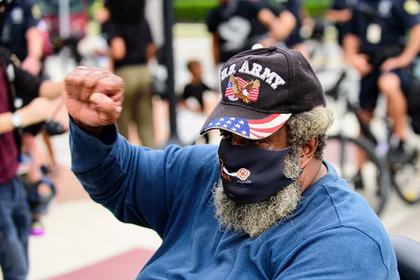 Orlando, FL, SUA - 19 iunie 2020: Bărbat cu barbă într-o capcană a armatei americane în semn de protest, cu pumnul în sus. Lupta. Proteste mascate ale bătrânilor . — Fotografie, imagine de stoc