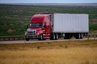 Arizona, ABD - Mayıs 2020: Amerikan yollarında kamyonlar. Teslimat. Büyük kırmızı bir kamyon ve dağlara karşı hareket halindeki kırsal yolda yazı için yeri olan bir römork..