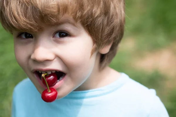 The child holds cherries in his mouth. Healthy food with natural vitamins. — Stock Photo, Image