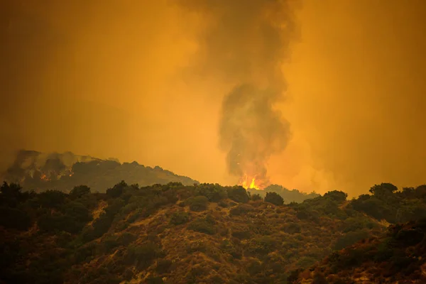 Fire in the mountains. Smoke in US air. Black smoke and orange sky due to fires in California. American fires threaten nature and human life. — Stock Photo, Image