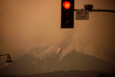 Los Angeles yakınlarında dağlar yanıyor. Kaliforniya 'da yangın. Duman ve hava kirliliği. Los Angeles sokakları duman içinde..
