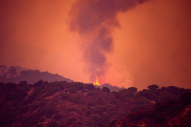Kaliforniya dağları üzerinde siyah duman ve turuncu gökyüzü. Amerika Birleşik Devletleri 'nin dağ ormanlarında yangınlar.