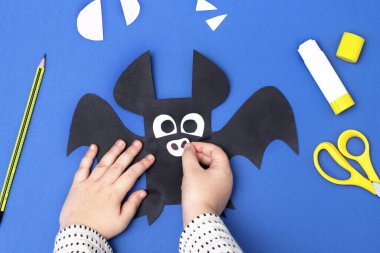 Cadılar Bayramı el yapımı dekor. Çocuk kağıt sopa yapıyor. Çocuk sanat projesi. Dördüncü adım. Üst manzara, düz uzanma