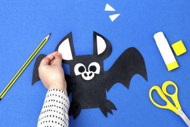 Cadılar Bayramı el yapımı dekor. Çocuk kağıt sopa yapıyor. Çocuk sanat projesi. Beşinci adım. Üst manzara, düz uzanma