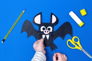 Cadılar Bayramı el yapımı dekor. Çocuk kağıt sopa yapıyor. Çocuk sanat projesi. Altıncı adım. Üst manzara, düz uzanma