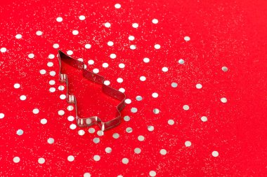 Noel ağacı şekilli, süslemeli ve kırmızı arka planda parıltılı. Düz yatış stili. Şenlik konsepti. Metin için yer.