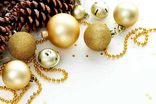 Noel ve yeni yıl arkaplanı süslemeler ve boncuklarla dolu. Altın parıldayan toplar, köknar kozalakları, ziller ve yıldız konfetileri. Tebrik kartı için arkaplan.