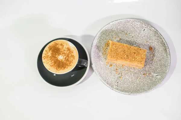 Cappuccino and Napoleon cake on a white background close-up