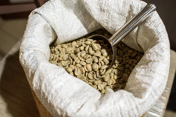 Green coffee beans in a bag in a cozy coffee shop