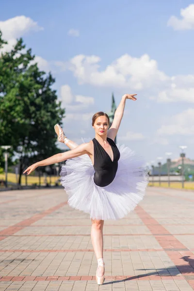 Young and beautiful ballerina posing on the street