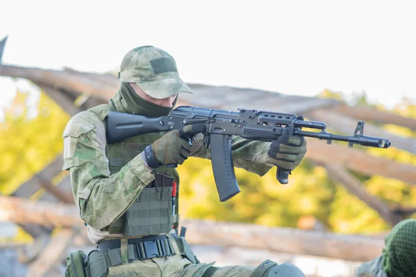 The airsoft player holds the defense, takes aim at the enemy