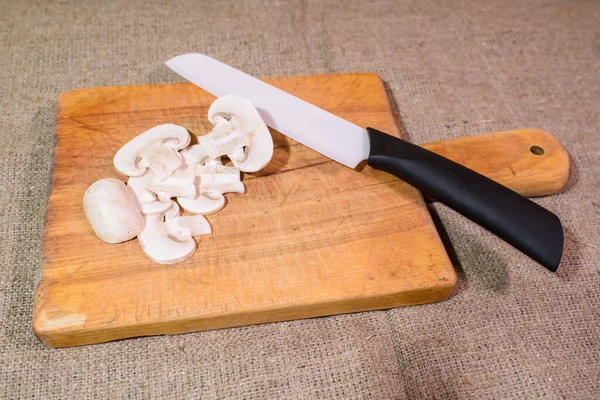 Fresh champignons on a cutting board and a knife