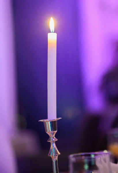 Burning candle on a table in a restaurant.