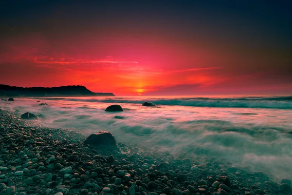 Amazing scarlet sunset over the evening sea, seascape in summer.