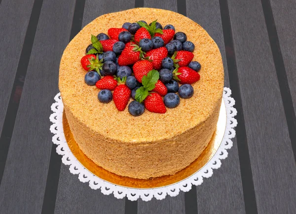 クルミ イチゴ ブルーベリー ミントの入った大きな3 Kgの蜂蜜のケーキがケーキの上を飾ります 暗い木のテーブルに — ストック写真
